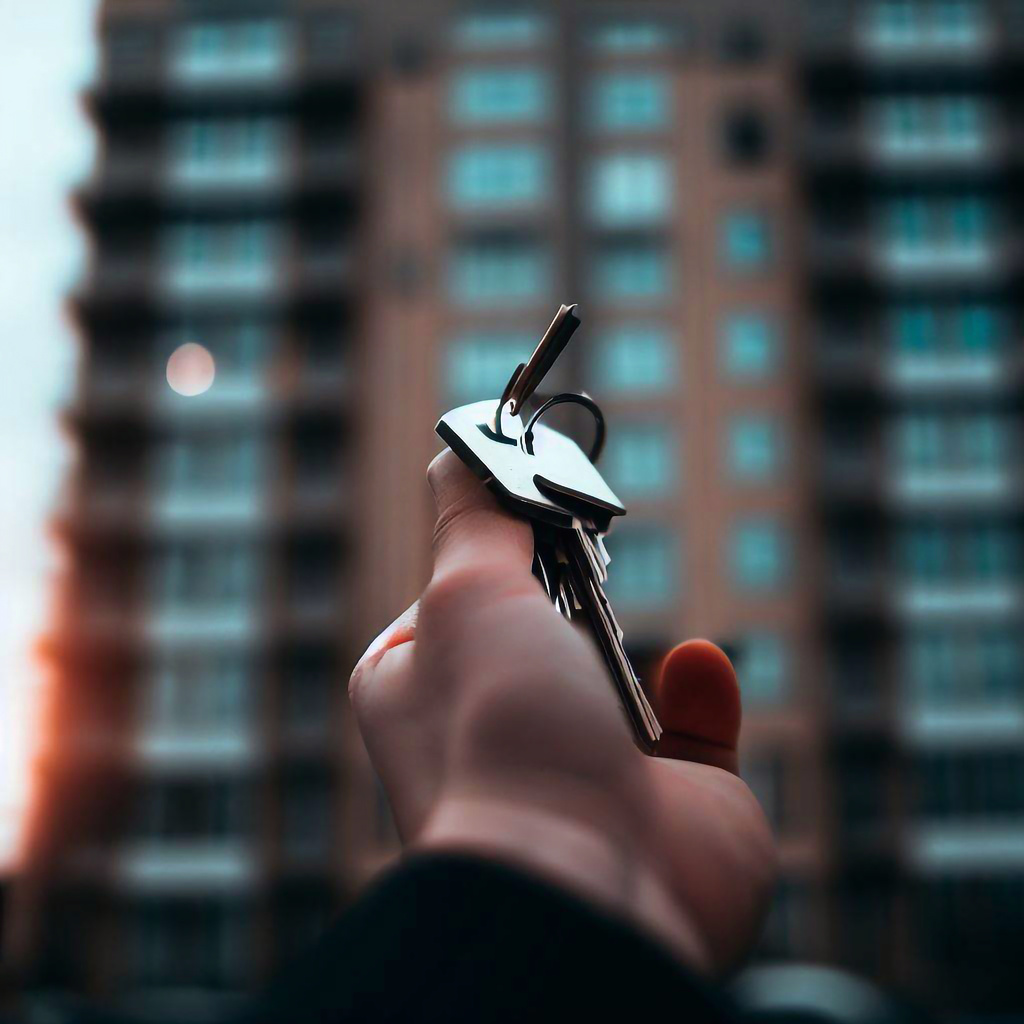 Keys in hand against the backdrop of an apartment building